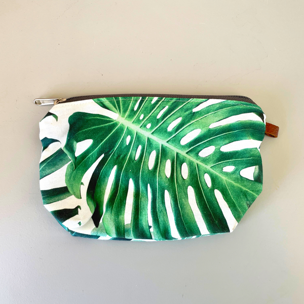 The green-floarl-linen-bag-has-a-leather-strap-and-zip